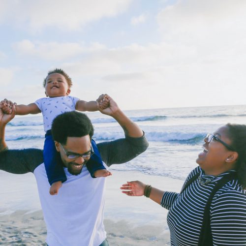 husband and wife on beach with child